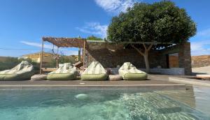 a pool with green inflatables in front of a house at Sea & Stone Villas in Koundouros