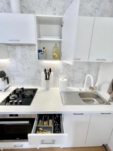 a kitchen with white cabinets and a sink at Rami studio apartment in Panevėžys