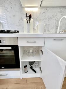 a kitchen with a white counter and a sink at Rami studio apartment in Panevėžys +12 photos