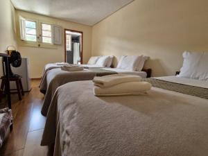 a hotel room with two beds with towels on them at Pousada Memórias de Minas in Ouro Preto