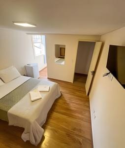 a bedroom with a bed and a flat screen tv at Pousada Memórias de Minas in Ouro Preto