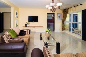 a living room with two couches and a glass table at Lagoon View Holiday Home in Montego Bay