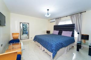 a bedroom with a bed and a desk and a tv at Lagoon View Holiday Home in Montego Bay