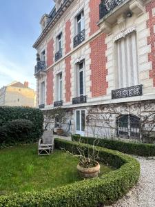 a building with a chair in front of it at La HALTE des CAVALIERS in Compiègne