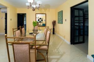 a dining room with a glass table and chairs at Lagoon View Holiday Home in Montego Bay