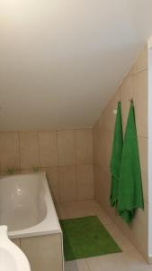 ein Badezimmer mit einer Badewanne und einem grünen Handtuch in der Unterkunft Ferienwohnung Blick auf die Berge in Pidingerau
