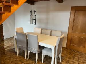 a dining room with a white table and chairs at Zweibettzimmer nah der A7 Tarp in Jerrishoe