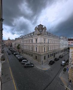 a large building with cars parked in a parking lot at Апарат готель під ЗОЛОТИМ КОРАБЛЕМ двохрівнева студія in Chernivtsi