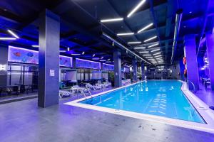 a large swimming pool with blue lighting in a building at National Hotel Ganja in Ganja