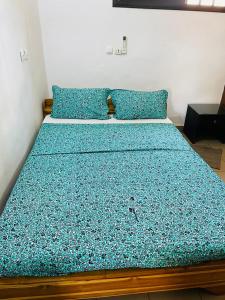 a bedroom with a bed with blue sheets and pillows at Agbevivi Boutique Hôtel in Aného