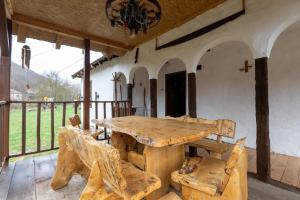 a large wooden table and chairs on a porch at Kmetova Bajka in Janja