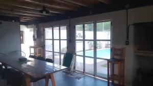 a dining room with a table and a view of a pool at Hospedaje La Pochi in Mocoretá