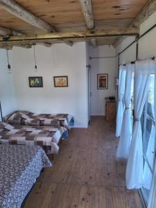 a room with four beds and a wooden floor at Hospedaje La Pochi in Mocoretá