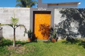 a yellow door on the side of a house with plants at Hospedaje La Pochi in Mocoretá