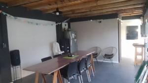a dining room with a wooden table and chairs at Hospedaje La Pochi in Mocoretá