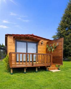 a wooden house with a large deck in the grass at Quintinha de Sá in Arnoso