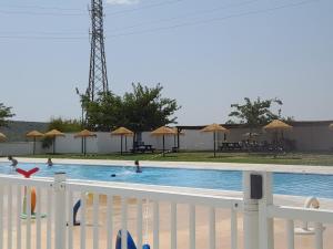 a pool with people swimming in it with umbrellas at A Beautiful Townhouse with a roof top terrace in Rute