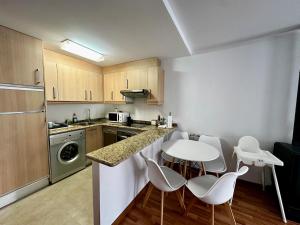 a kitchen with a table and white chairs in it at Valdelinares 365 in Valdelinares