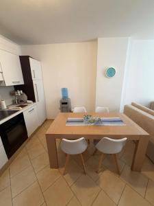 a kitchen and dining room with a wooden table and chairs at Aldi APARTMENTS in Lezhë