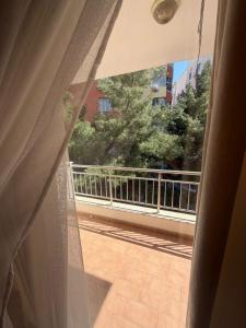 a window with a view of a balcony with trees at Aldi APARTMENTS in Lezhë