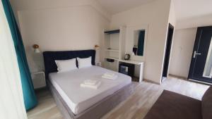 a bedroom with a white bed in a room at Sunny Beach Potos in Potos