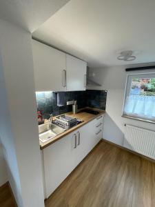 a kitchen with white cabinets and a sink and a window at Bo's 3Eins in Schwäbisch Hall +7 photos