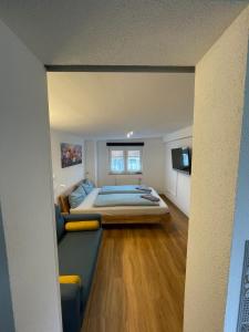 a bedroom with a bed and a couch and a television at Bo's 3Eins in Schwäbisch Hall
