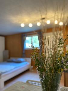 a vase with flowers on a table in a bedroom at Holiday accomodation appartamento in seminterrato in Coglio