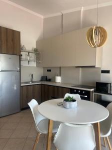 a kitchen with a white table and white chairs at Casita Dos in Ofrínion