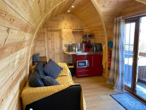 a living room with a couch in a tiny house at Hatterall View Glamping Pod in Abergavenny
