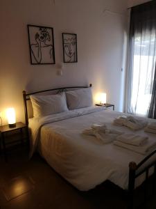 a bedroom with a large white bed with towels on it at Nord Guesthouse in Neos Pirgos