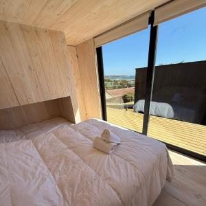 a bedroom with a bed with a towel on it at Costa Lodge Pichilemu in Pichilemu
