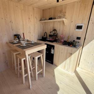a kitchen with a table and chairs in a cabin at Costa Lodge Pichilemu in Pichilemu +12 photos