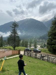 a young boy is flying a kite in a field at Lala Ji coasy cottage in Pahalgām +10 photos