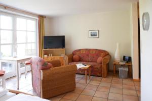 a living room with a couch and a tv at Landhaus am Esch in Warendorf