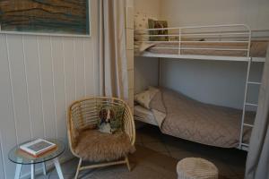 a room with a chair and a bunk bed at Thula - Apartment in Villa Ambrosian in Trzebież