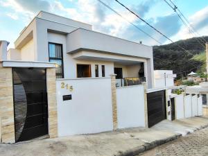 a house with two white doors and a garage at Casa para 4 pessoas I Churrasqueira I Garagem para 2 carros I 5min do centro in São Lourenço