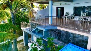 a house with a swimming pool and a balcony at Rooms on ocean view in Grand-Baie