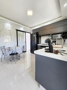 a kitchen and dining room with a table and chairs at Casa para 4 pessoas I Churrasqueira I Garagem para 2 carros I 5min do centro in São Lourenço