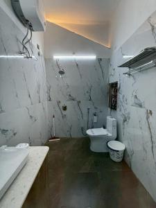 a white bathroom with a toilet and a sink at Rudreshwar Mahadeo Kothi in Varanasi +44 photos