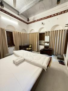 a bedroom with a large white bed in a room at Rudreshwar Mahadeo Kothi in Varanasi