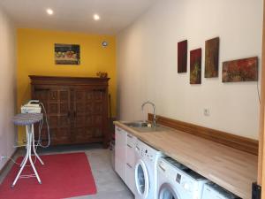 a kitchen with a washing machine and a sink at Le Moulin du Bourg in Épeigné-les-Bois