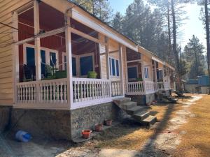 a house with a porch with potted plants on it at Lala Ji coasy cottage in Pahalgām