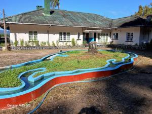 a painting of a river in front of a house at Gleanloch Holiday Resort in Tawalantenna