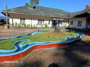 a painting of a river in front of a house at Gleanloch Holiday Resort in Tawalantenna