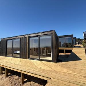 a tiny house sitting on a wooden deck at Costa Lodge Pichilemu in Pichilemu