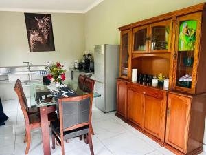 a kitchen with a table and chairs and a refrigerator at Pholanathi Lodge in Cliffdale