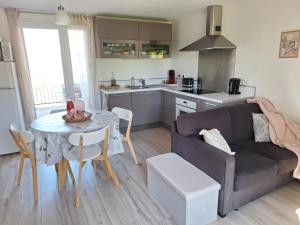a kitchen and a living room with a couch and a table at Le gîte Bellevue in Firmi