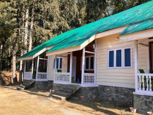 a small house with a green tin roof at Lala Ji coasy cottage in Pahalgām