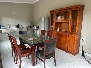 a dining room with a table and chairs and a kitchen at Pholanathi Lodge in Cliffdale +23 photos